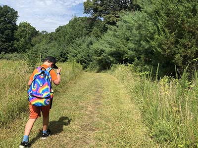 Child hiking on trail through field