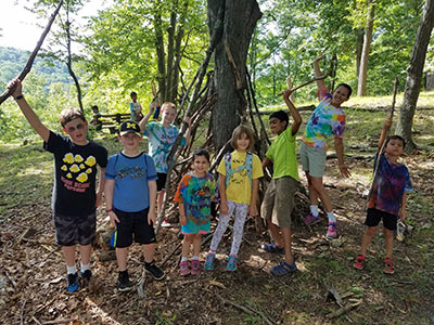 Kids holding sticks at camp